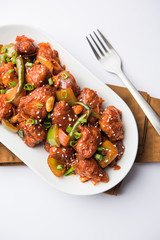 Indian Chilli Chicken dry, served in a plate over moody background. Selective focus