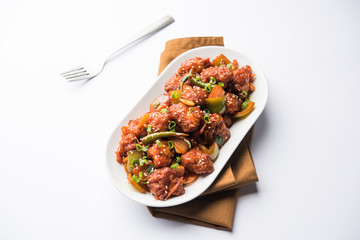 Indian Chilli Chicken dry, served in a plate over moody background. Selective focus
