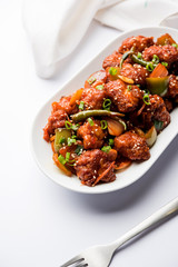 Indian Chilli Chicken dry, served in a plate over moody background. Selective focus