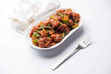 Indian Chilli Chicken dry, served in a plate over moody background. Selective focus