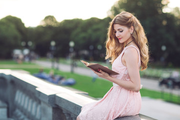 Young girl reading a book in the Park.