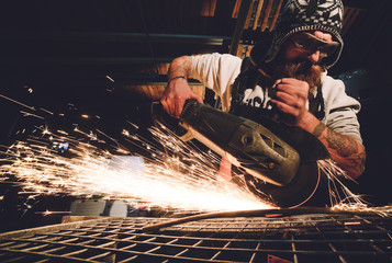 Worker Using Angle Grinder in Factory and throwing sparks