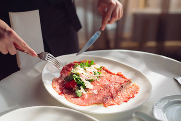 Red beef carpaccio in a white plate,