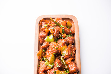 Indian Chilli Chicken dry, served in a plate over moody background. Selective focus