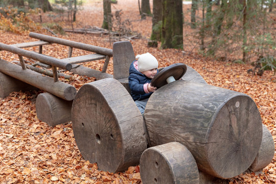 Babygirl riding a wooden toy truck