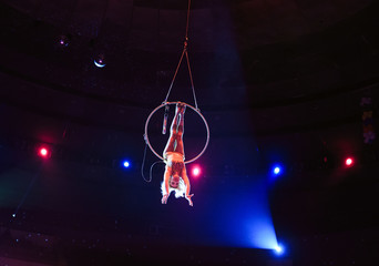 Aerial acrobat in the ring. A young girl performs the acrobatic elements in the air ring.