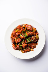 Indian Chilli Chicken dry, served in a plate over moody background. Selective focus