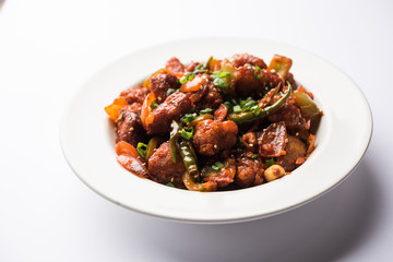 Indian Chilli Chicken dry, served in a plate over moody background. Selective focus