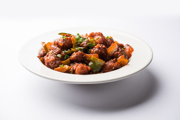 Indian Chilli Chicken dry, served in a plate over moody background. Selective focus