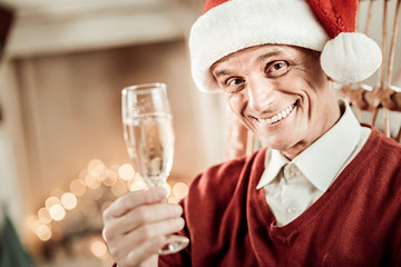 Happy senior man smiling and holding a glass.