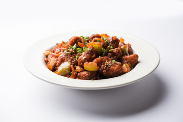 Indian Chilli Chicken dry, served in a plate over moody background. Selective focus