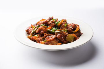 Indian Chilli Chicken dry, served in a plate over moody background. Selective focus