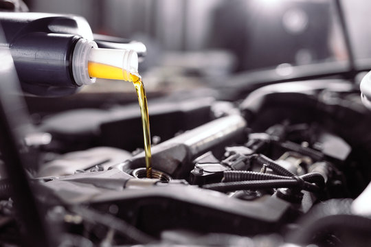 Motor Oil Pouring To Car Engine.