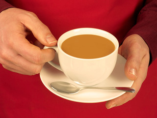 MAN HOLDING CUP OF COFFEE WITH MILK