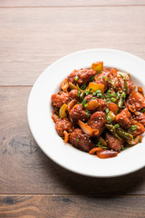 Indian Chilli Chicken dry, served in a plate over moody background. Selective focus