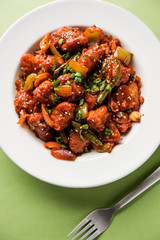 Indian Chilli Chicken dry, served in a plate over moody background. Selective focus