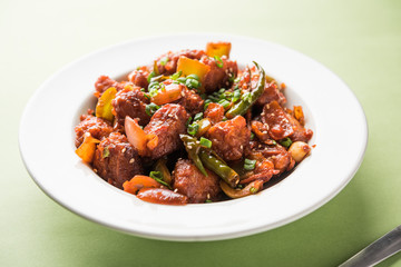 Indian Chilli Chicken dry, served in a plate over moody background. Selective focus