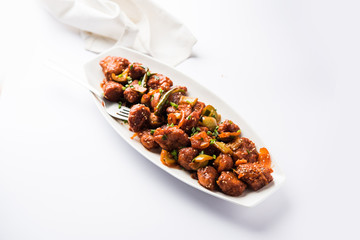 Indian Chilli Chicken dry, served in a plate over moody background. Selective focus