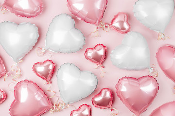 Air Balloons of heart shaped foil  on pastel pink background. Love concept. Holiday celebration....