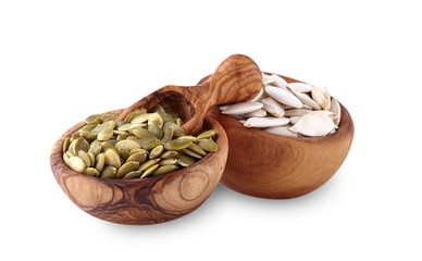 pumpkin seeds in  wooden plates on a white background
