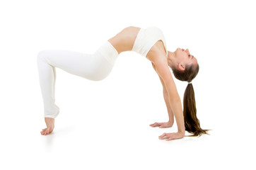 A young woman in a white suit performs acrobatic elements and yoga.