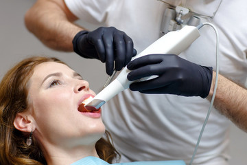 The dentist scans the patient's teeth with a 3d scanner.