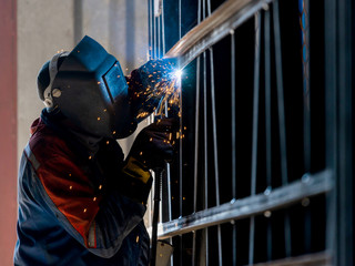 Industrial Worker labourer at the factory arc welding steel structure