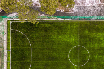 A stadium with a green soccer field, aerial view