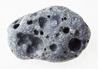 pebble from gray porous pumice stone on white