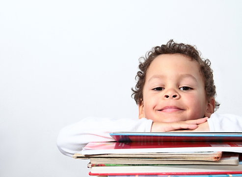 little boy leaning on his school books stock photo