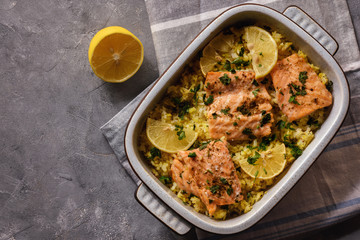 Salmon baked on oven with rice and lemon.