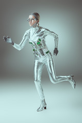 Fototapeta na wymiar full length view of silver woman robot running on grey, future technology concept