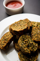 Cilantro cake or Kothimbir Vadi is a popular maharashtrian cuisine made with cilantro leaves. served with tomato ketchup. selective focus