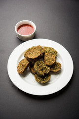 Cilantro cake or Kothimbir Vadi is a popular maharashtrian cuisine made with cilantro leaves. served with tomato ketchup. selective focus