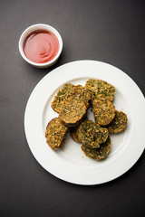Cilantro cake or Kothimbir Vadi is a popular maharashtrian cuisine made with cilantro leaves. served with tomato ketchup. selective focus