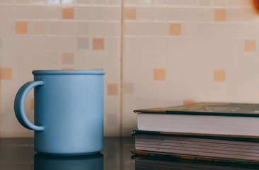 Coffee cup besides books