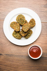 Cilantro cake or Kothimbir Vadi is a popular maharashtrian cuisine made with cilantro leaves. served with tomato ketchup. selective focus