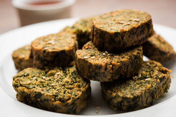 Cilantro cake or Kothimbir Vadi is a popular maharashtrian cuisine made with cilantro leaves. served with tomato ketchup. selective focus