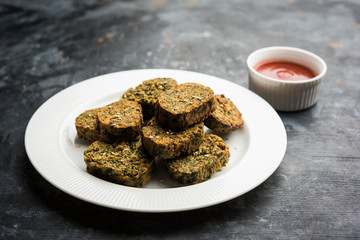 Cilantro cake or Kothimbir Vadi is a popular maharashtrian cuisine made with cilantro leaves. served with tomato ketchup. selective focus
