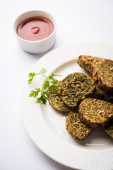 Cilantro cake or Kothimbir Vadi is a popular maharashtrian cuisine made with cilantro leaves. served with tomato ketchup. selective focus