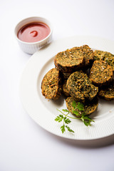 Cilantro cake or Kothimbir Vadi is a popular maharashtrian cuisine made with cilantro leaves. served with tomato ketchup. selective focus