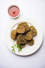 Cilantro cake or Kothimbir Vadi is a popular maharashtrian cuisine made with cilantro leaves. served with tomato ketchup. selective focus