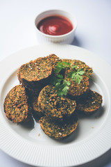 Cilantro cake or Kothimbir Vadi is a popular maharashtrian cuisine made with cilantro leaves. served with tomato ketchup. selective focus