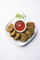 Cilantro cake or Kothimbir Vadi is a popular maharashtrian cuisine made with cilantro leaves. served with tomato ketchup. selective focus