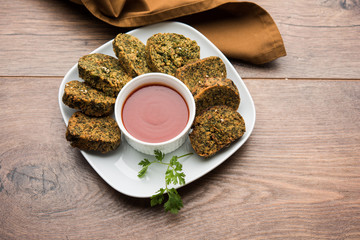 Cilantro cake or Kothimbir Vadi is a popular maharashtrian cuisine made with cilantro leaves. served with tomato ketchup. selective focus