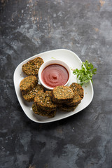 Cilantro cake or Kothimbir Vadi is a popular maharashtrian cuisine made with cilantro leaves. served with tomato ketchup. selective focus