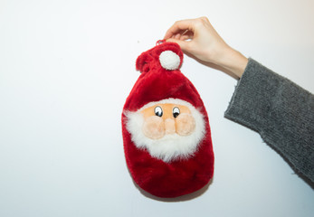A red white Santa Claus Christmas Sock is hung on a wall 