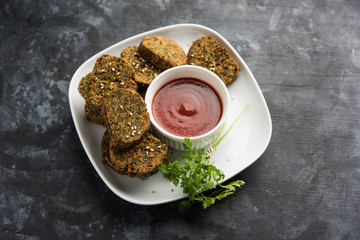 Cilantro cake or Kothimbir Vadi is a popular maharashtrian cuisine made with cilantro leaves. served with tomato ketchup. selective focus