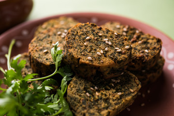 Cilantro cake or Kothimbir Vadi is a popular maharashtrian cuisine made with cilantro leaves. served with tomato ketchup. selective focus
