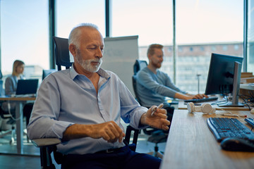 Senior businessman sitting at desk in office